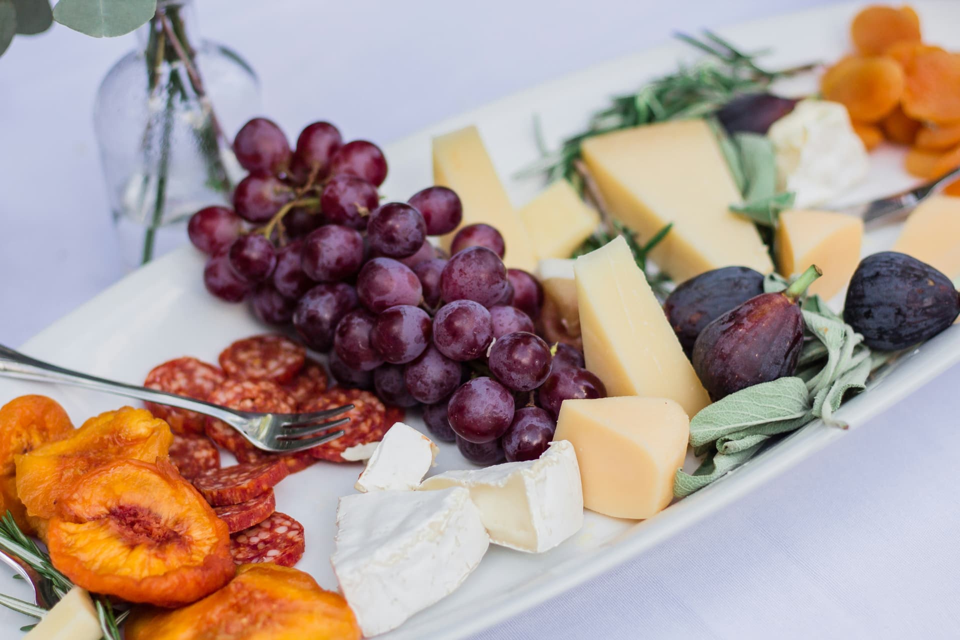 Cheese board with grapes, figs, dried fruit and cured meats