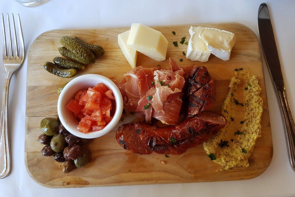 Wooden charcuterie board with cured meats and cheeses